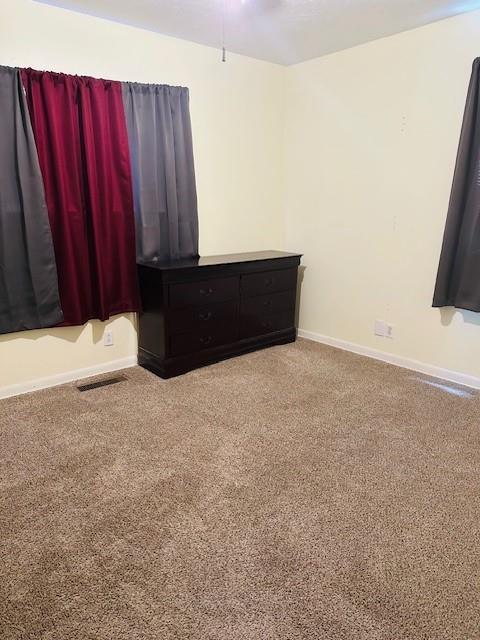 carpeted spare room with ceiling fan