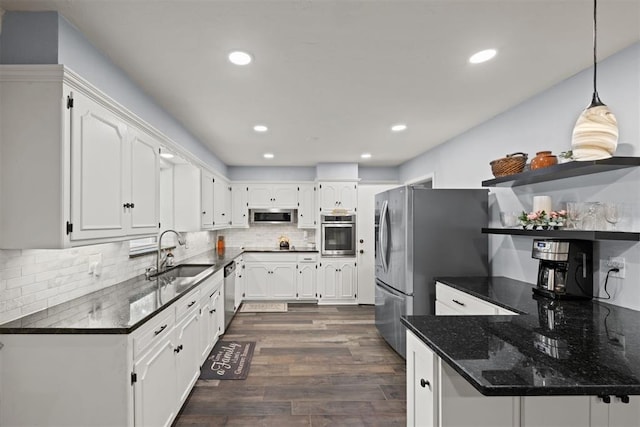 kitchen with white cabinetry, sink, hanging light fixtures, dark hardwood / wood-style flooring, and appliances with stainless steel finishes