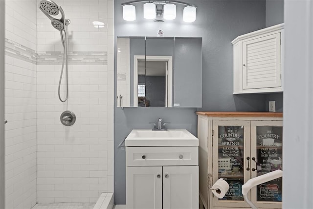 bathroom with vanity and tiled shower