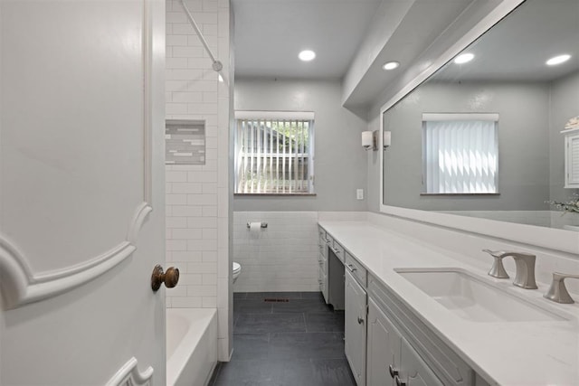 full bathroom with tile patterned flooring, vanity, tiled shower / bath combo, and toilet