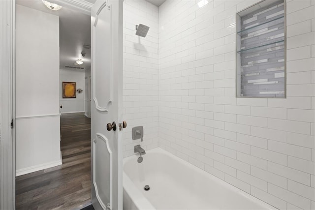 bathroom with hardwood / wood-style floors and tiled shower / bath combo