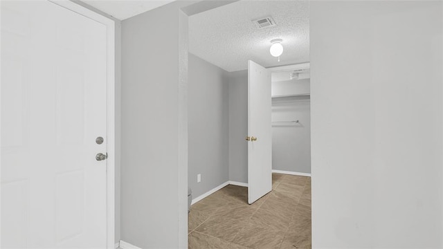 hallway with a textured ceiling