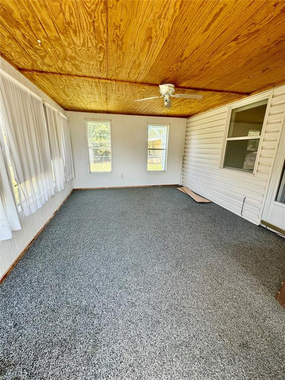 unfurnished sunroom with ceiling fan and wooden ceiling