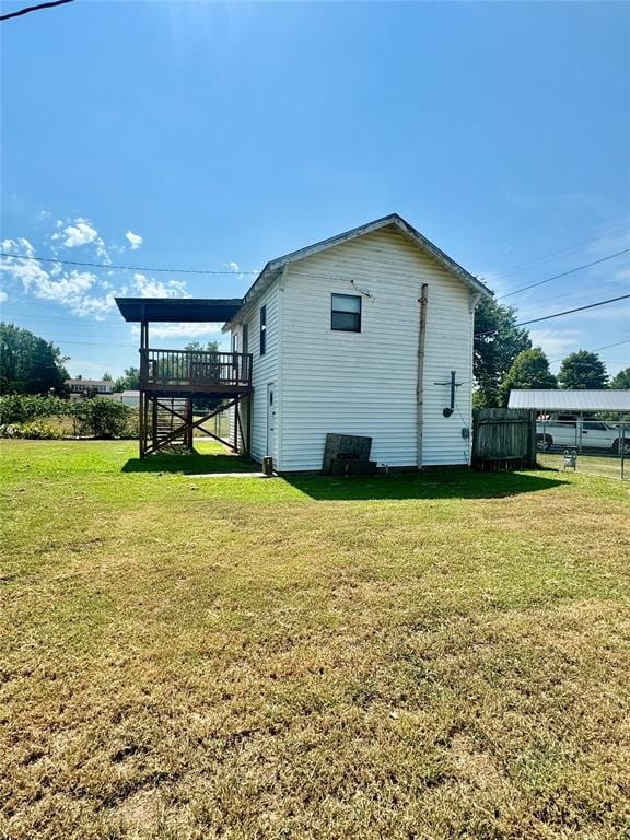 view of side of property with a lawn and a deck