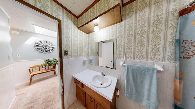 bathroom featuring vanity and tile walls