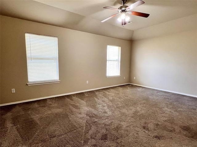 spare room with dark colored carpet, ceiling fan, and lofted ceiling