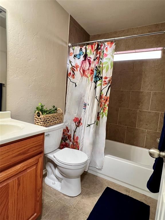 full bathroom with tile patterned floors, shower / bath combo, toilet, and vanity