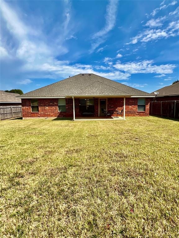 rear view of property with a lawn and a patio