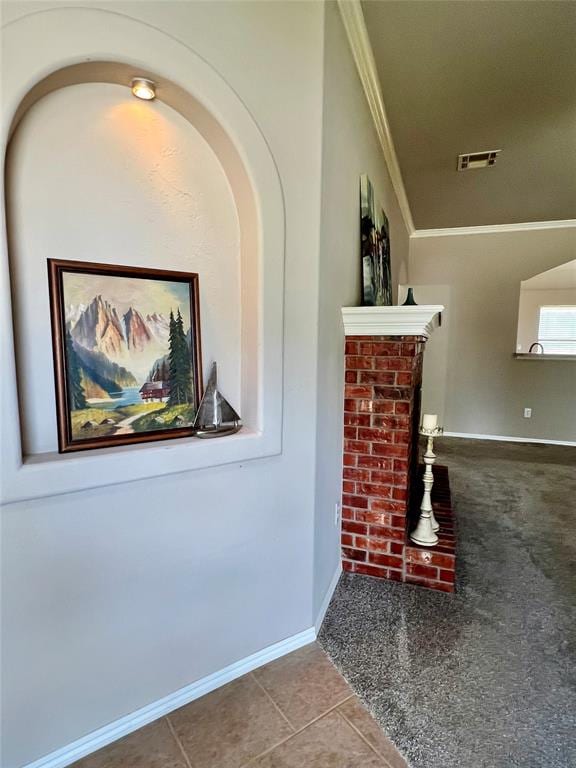 corridor with tile patterned floors and crown molding