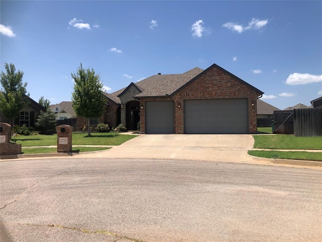 ranch-style house featuring a garage and a front lawn