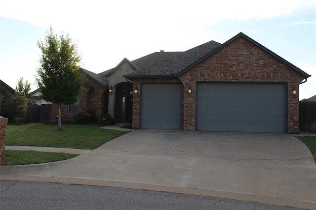 ranch-style home featuring a garage and a front yard