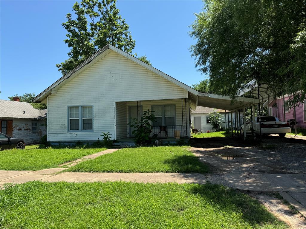 bungalow with a front yard and a carport