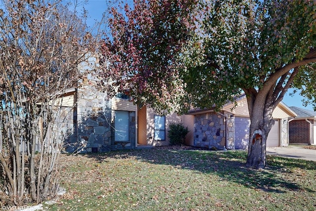 obstructed view of property featuring a garage and a front lawn