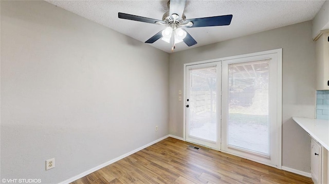 interior space featuring ceiling fan, light hardwood / wood-style floors, and a textured ceiling