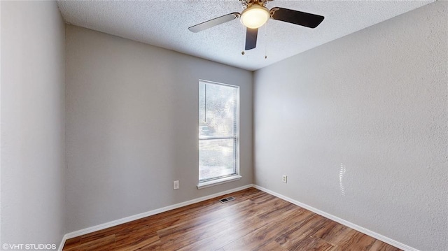 empty room with ceiling fan, a textured ceiling, and hardwood / wood-style flooring