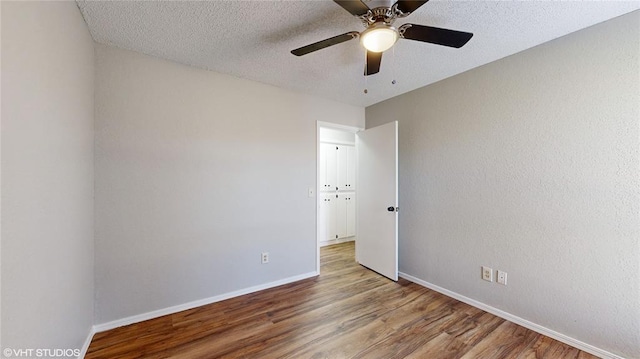 spare room with ceiling fan, a textured ceiling, and hardwood / wood-style flooring