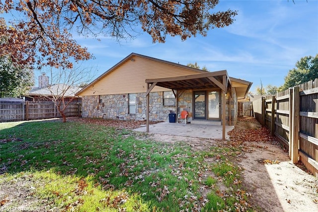 rear view of property with a yard and a patio