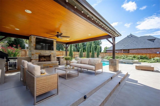 view of patio / terrace with a fenced in pool, an outdoor living space with a fireplace, and ceiling fan