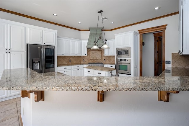 kitchen with kitchen peninsula, a kitchen bar, light stone counters, stainless steel appliances, and white cabinetry