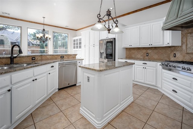 kitchen with sink, hanging light fixtures, stainless steel appliances, a kitchen island, and white cabinets