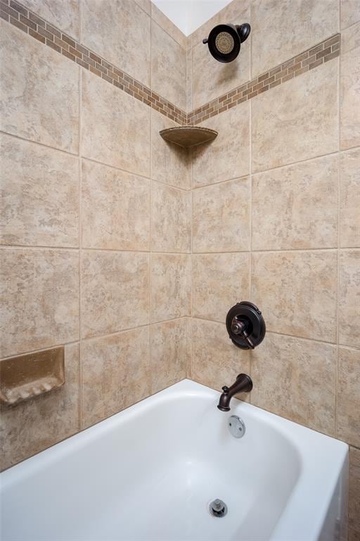 bathroom featuring tiled shower / bath