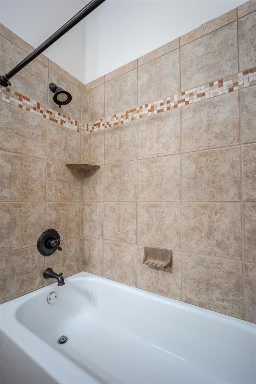 bathroom featuring tiled shower / bath