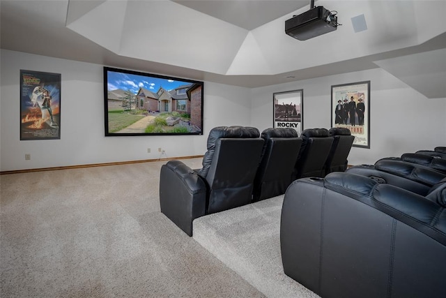 home theater room featuring carpet flooring and a raised ceiling