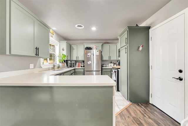 208 S Mockingbird Dr, Altus, OK 73521 - kitchen with freestanding refrigerator, a sink, a peninsula, light countertops, and recessed lighting