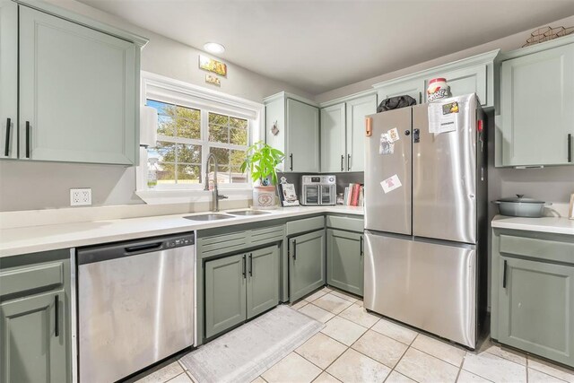 208 S Mockingbird Dr, Altus, OK 73521 - kitchen with appliances with stainless steel finishes, a sink, green cabinetry, light tile patterned floors, and light countertops