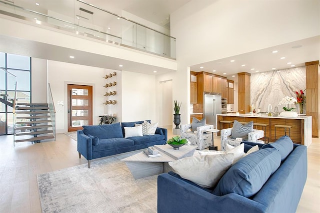 living room featuring light hardwood / wood-style flooring and a towering ceiling