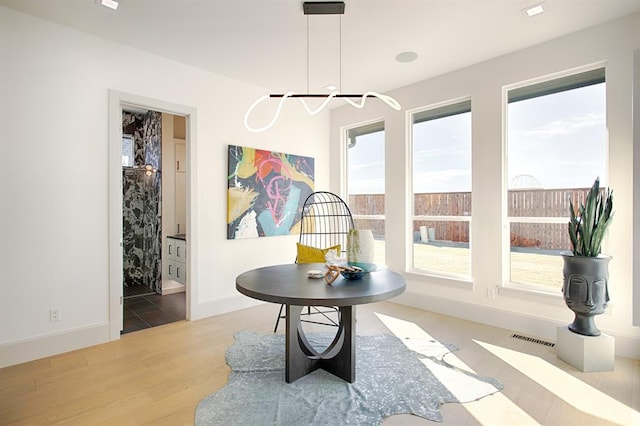 dining area with light hardwood / wood-style flooring and a notable chandelier