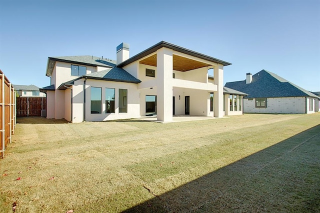 rear view of property featuring a lawn and a patio