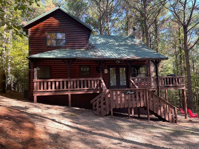 log-style house featuring french doors and a deck