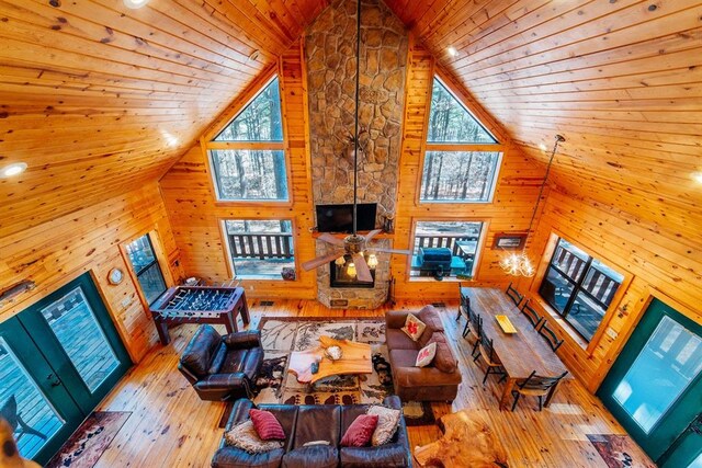 unfurnished living room featuring light hardwood / wood-style floors, wooden ceiling, and wooden walls