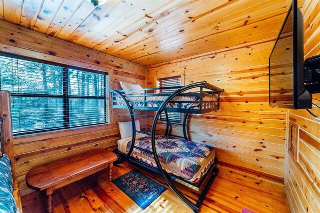 bedroom featuring wooden walls and wood-type flooring