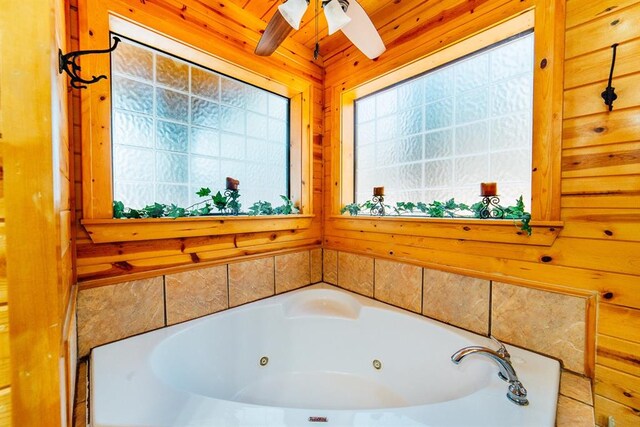 bathroom featuring ceiling fan, beam ceiling, wood ceiling, and a tub