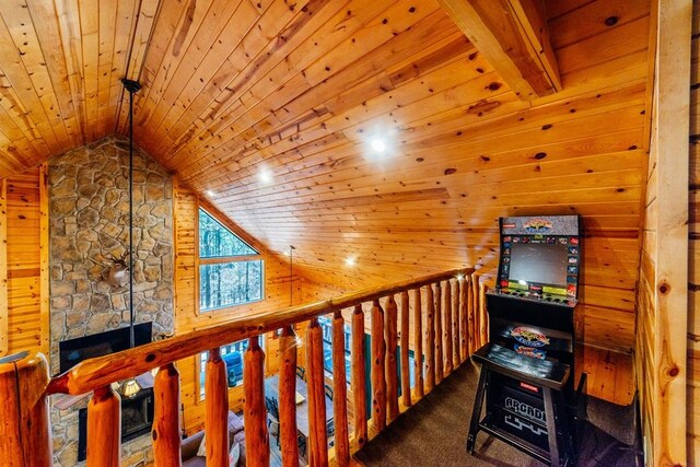 hall with carpet, lofted ceiling with beams, wooden ceiling, and wooden walls