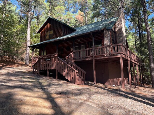 rear view of house featuring a wooden deck