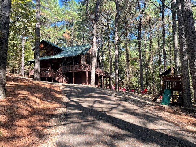 view of property exterior with a playground and a deck