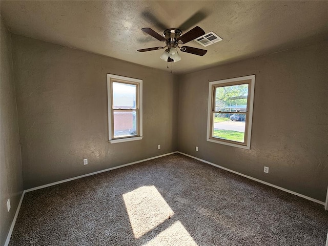 carpeted empty room featuring ceiling fan and a textured ceiling