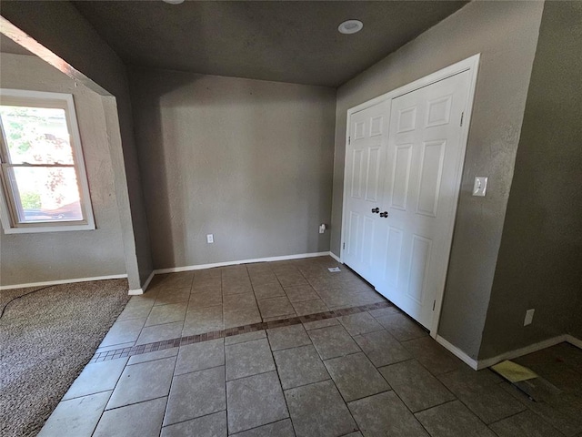 unfurnished bedroom with dark tile patterned flooring