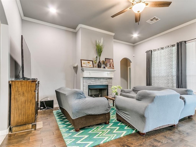 1301 Atalon Dr, Moore, OK 73160 - living area with arched walkways, hardwood / wood-style flooring, a ceiling fan, ornamental molding, and a fireplace