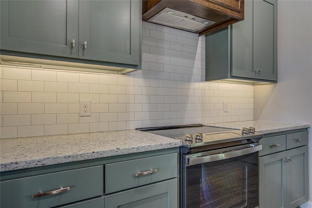 kitchen with premium range hood, electric range, tasteful backsplash, and light stone counters