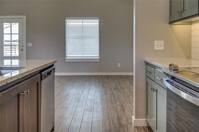 kitchen featuring light stone countertops, dishwasher, dark wood-type flooring, and range