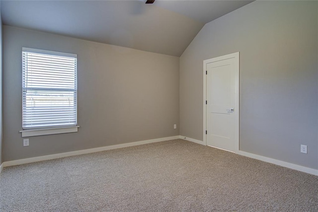 spare room featuring carpet and lofted ceiling