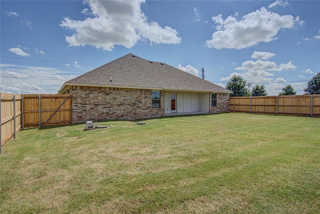 rear view of property with a yard