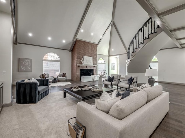 living room with ornamental molding, a fireplace, a healthy amount of sunlight, and hardwood / wood-style flooring