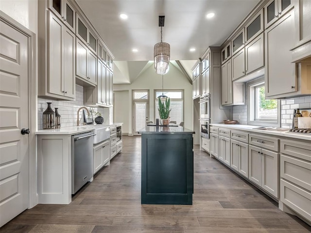 kitchen featuring decorative backsplash, dark hardwood / wood-style flooring, hanging light fixtures, and appliances with stainless steel finishes