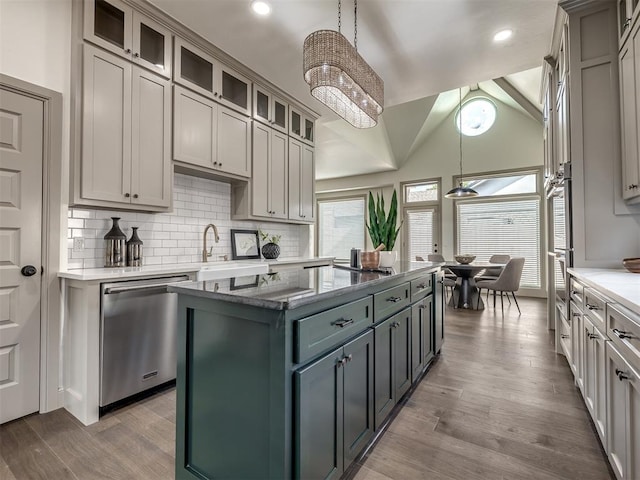 kitchen featuring a center island, stainless steel dishwasher, decorative light fixtures, and light hardwood / wood-style flooring