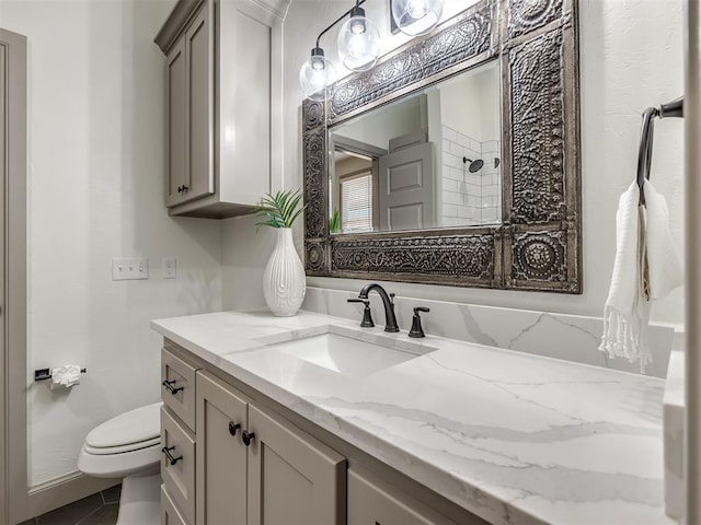 bathroom with a tile shower, tile patterned flooring, vanity, and toilet